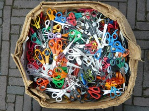 cardboard box full of scissors with brightly coloured handles