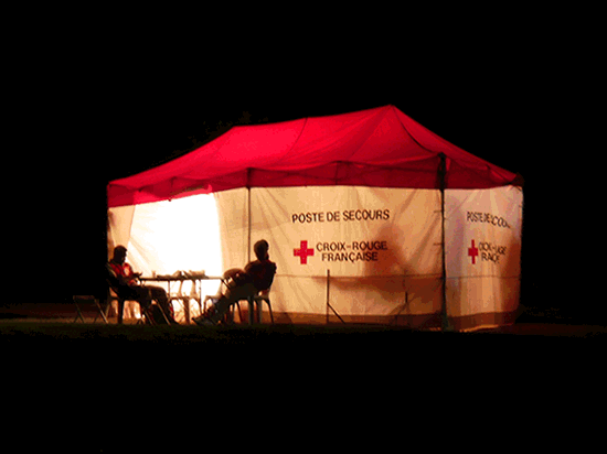 Animated loop of brightly lit first aid tent against a dark sky.