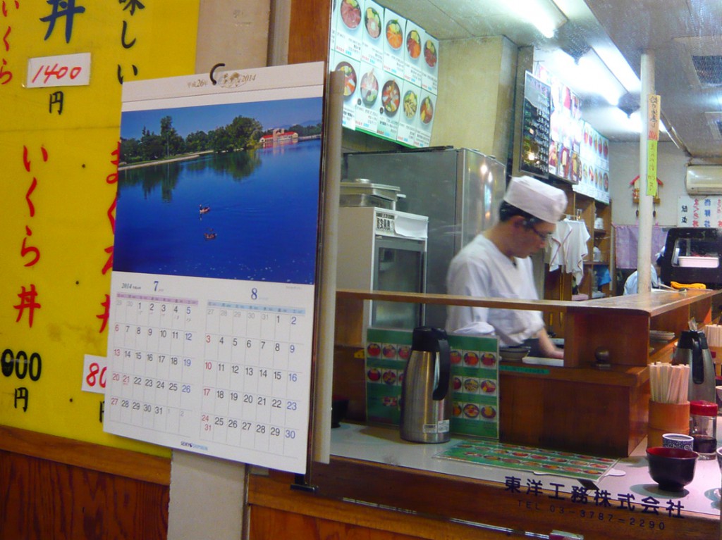 sushi chef working behind a counterreflected in a mirror